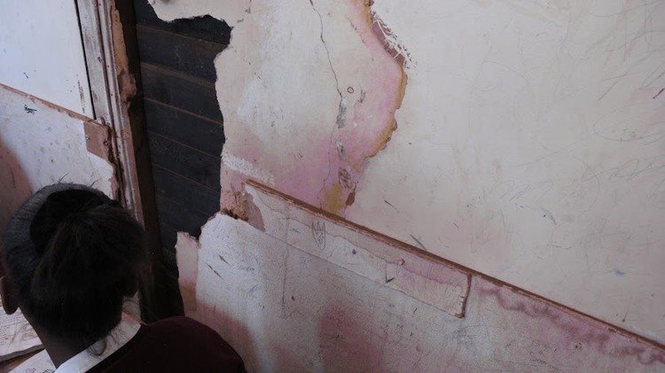 The are holes in the wall near the desks of learners in Kliptown Primary.