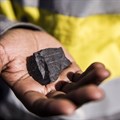 Miner holds a manganese ore sample in South Africa.