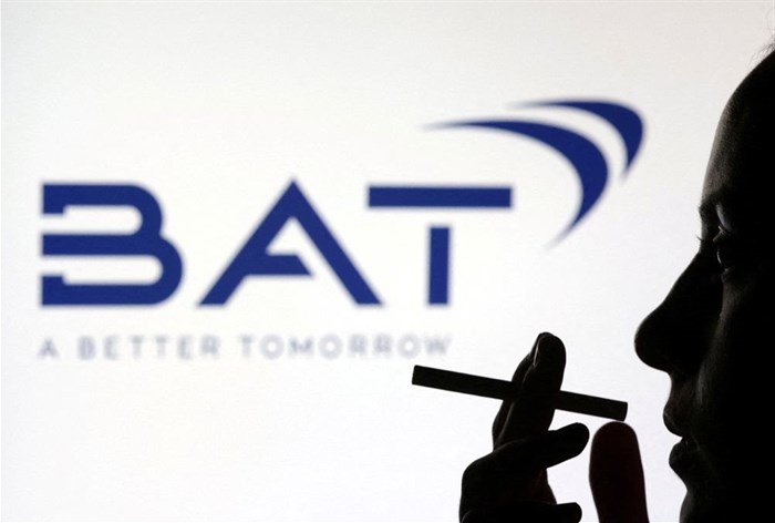 File photo: A woman poses with a cigarette in front of BAT (British American Tobacco) logo in this illustration taken 26 July 2022. Reuters/Dado Ruvic/Illustration/File Photo