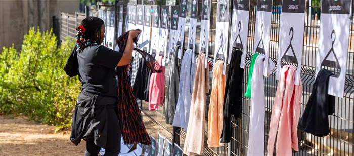Image supplied. A Superbalist volunteer sets up clothing hangers to display items in the Street Store