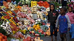 Children walk past a vegetable stall in Soweto 23 July 2015. Reuters/Siphiwe Sibeko/file photo