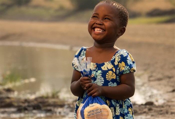 Source: © Lungisa Mjaji  Photographer Lungisani Mjaji, who captured this beautiful picture of his niece Lethukukhanya Mjaji, smiling and holding a loaf of Albany bread that went viral last year has hit out at the brand on social media
