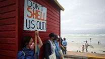 A protestor holds a placard as she joins a demonstration against oil major Royal Dutch Shell's plans to start seismic surveys to explore petroleum systems off the country's popular Wild Coast, at Muizenberg beach in Cape Town. Source: Reuters/Mike Hutchings