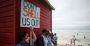 A protestor holds a placard as she joins a demonstration against oil major Royal Dutch Shell's plans to start seismic surveys to explore petroleum systems off the country's popular Wild Coast, at Muizenberg beach in Cape Town. Source: Reuters/Mike Hutchings