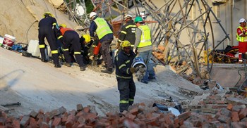 A rescue worker removes rubble from the site where construction workers are trapped under a building that collapsed in George. Source: Reuters/Esa Alexander