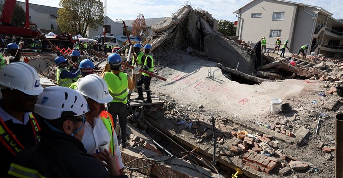 Rescuers work to rescue construction workers trapped under a building that collapsed in George. Source: Reuters/Esa Alexander