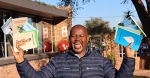 Kumba Iron Ore's Walter Khumo showcasing the newly published books. Image supplied.