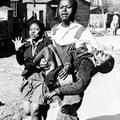 Mbuyisa Makhubu carries Hector Pieterson after Pieterson was shot and killed at the Soweto Uprising. Antoinette Sithol, Pieterson's sister, runs beside them. Image credit: , via Wikimedia Commons