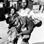 Mbuyisa Makhubu carries Hector Pieterson after Pieterson was shot and killed at the Soweto Uprising. Antoinette Sithol, Pieterson's sister, runs beside them. Image credit: , via Wikimedia Commons