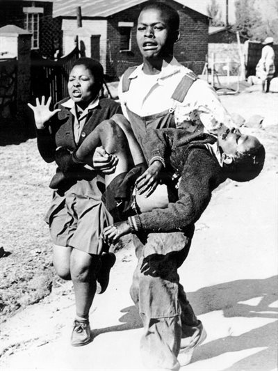 Mbuyisa Makhubu carries Hector Pieterson after Pieterson was shot and killed at the Soweto Uprising. Antoinette Sithol, Pieterson's sister, runs beside them. Image credit: , via Wikimedia Commons