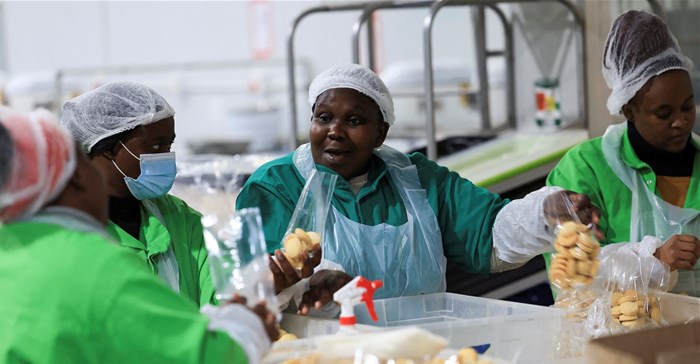 Source: Reuters/Esa Alexander. Workers interact while working on the production line at the factory of Khayelitsha Cookies, a Cape Town biscuit maker, in Cape Town, South Africa, 11 May, 2026.