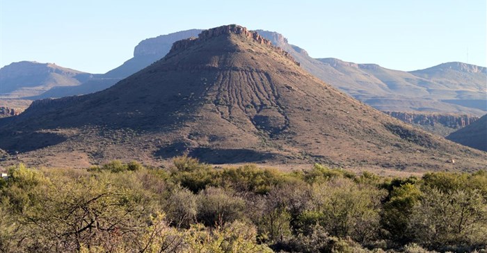 Hill in siliciclastic strata (mud or siltstones capped by solid sandstone) of Teekloof or Abrahamskraal formation (Beaufort Group) of the main Karoo Basin. Image credit: , , via Wikimedia Commons