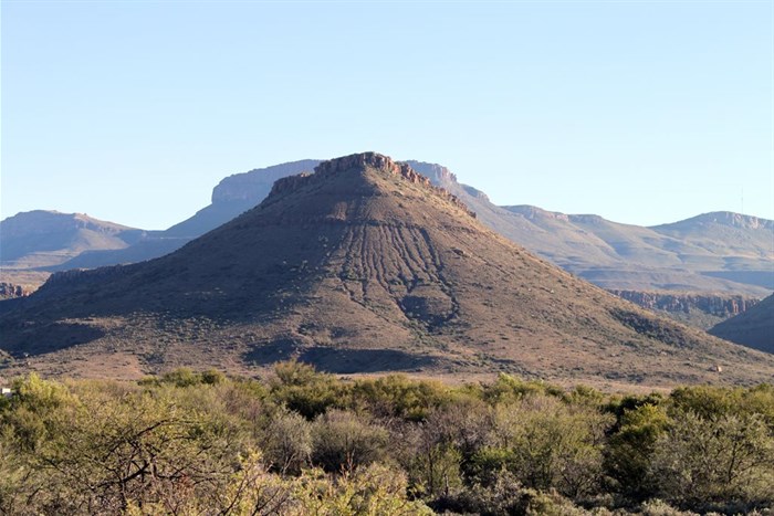 Hill in siliciclastic strata (mud or siltstones capped by solid sandstone) of Teekloof or Abrahamskraal formation (Beaufort Group) of the main Karoo Basin. Image credit: , , via Wikimedia Commons