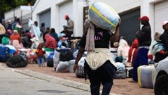 A Zimbabwean migrant carries luggage outside the Zimbabwe Consulate amid fears of anti-immigrant violence ahead of a June 30 deadline set by activists demanding undocumented migrants leave the country, in Cape Town, South Africa, June 22, 2026. REUTERS/Esa Alexander