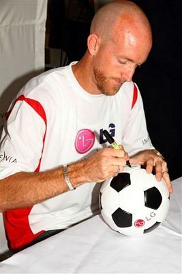 Matthew Booth signs a soccer balls.